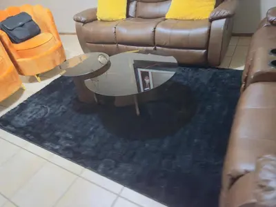 a living room with a couch and a blue rug at Luxury two bedrooms apartment in Witbank overnight accommodation in Witbank
