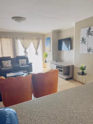 a living room with a couch and a table and chairs at Luxury two bedrooms apartment in Witbank overnight accommodation in Witbank
