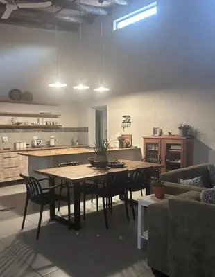 a living room with a table and chairs and a kitchen at Ingonyama Rest in Marloth Park