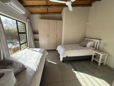 a bedroom with two beds and a window at Ingonyama Rest in Marloth Park