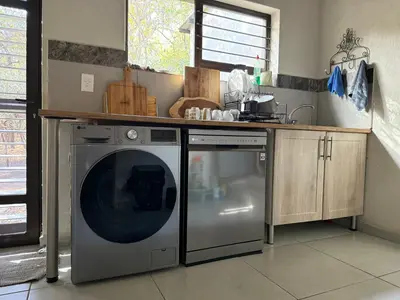 a kitchen with a washing machine and a counter at Ingonyama Rest in Marloth Park