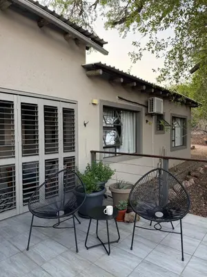 two chairs on a patio in front of a house at Ingonyama Rest in Marloth Park