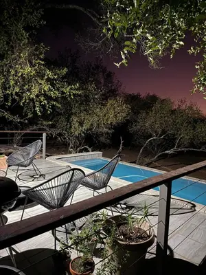 a deck with two chairs and a swimming pool at Ingonyama Rest in Marloth Park