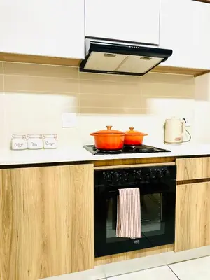a kitchen with a stove with two pots on it at Beach-Style Modern Apt at The Blyde in Pretoria