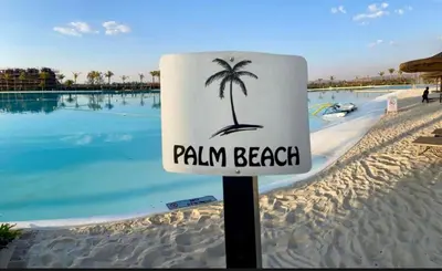 a sign on a beach with a palm tree on it at Beach-Style Modern Apt at The Blyde in Pretoria