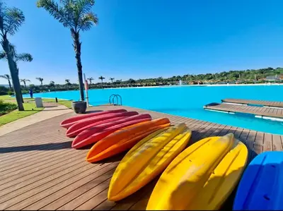 four surfboards lined up on a wooden table next to a pool at Beach-Style Modern Apt at The Blyde in Pretoria