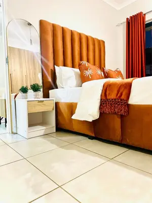 a large bed with a large headboard in a room at Beach-Style Modern Apt at The Blyde in Pretoria