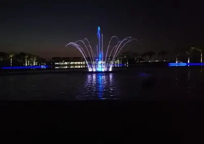 a fountain in the middle of the water at night at Beach-Style Modern Apt at The Blyde in Pretoria