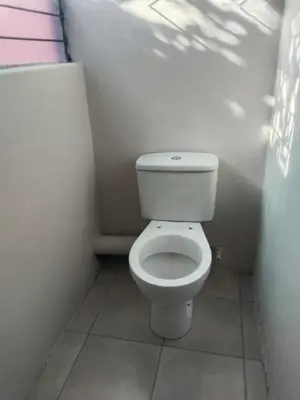a bathroom with a white toilet in a room at Rasesa Guesthouse Block V in Soshanguve