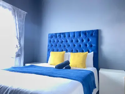 a blue bed with a teddy bear sitting on it at A spacious 1bedroom apartment in the heart of Kempton Park in Kempton Park