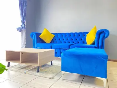 a living room with a blue couch and a coffee table at A spacious 1bedroom apartment in the heart of Kempton Park in Kempton Park