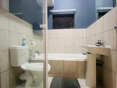 a bathroom with a toilet and a sink at A spacious 1bedroom apartment in the heart of Kempton Park in Kempton Park