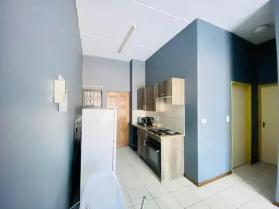 a kitchen with a refrigerator and a stove top oven at A spacious 1bedroom apartment in the heart of Kempton Park in Kempton Park