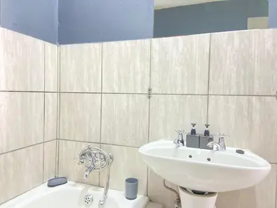 a bathroom with a sink and a bath tub at A spacious 1bedroom apartment in the heart of Kempton Park in Kempton Park