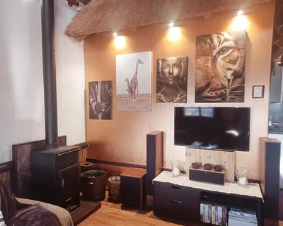 a living room with a television and pictures on the wall at Private Lodge at Vaalkop Dam Reserve in Beestekraal