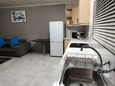 a kitchen with a sink and a refrigerator at Little Swift 1 in Secunda
