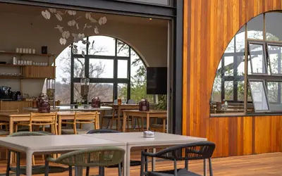 a restaurant with tables and chairs and windows at 18 On The Hill in Mica
