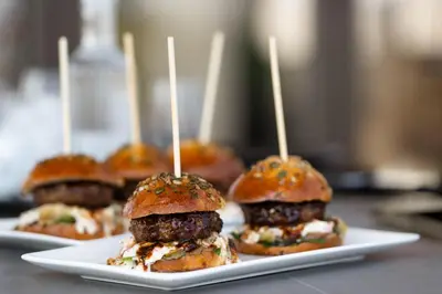a group of sandwiches on a plate with tooth picks at 18 On The Hill in Mica