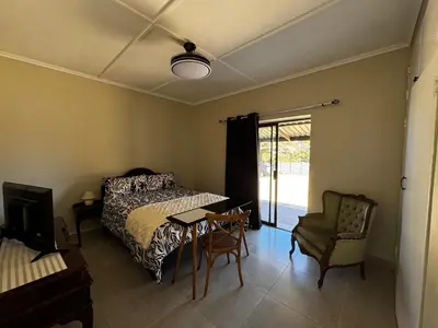 a bedroom with a bed and a table and a chair at Willow Cottage in Evander