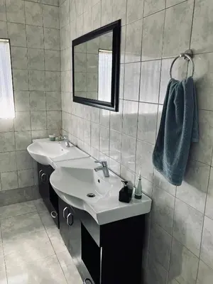 a bathroom with two sinks and a mirror at Willow Cottage in Evander