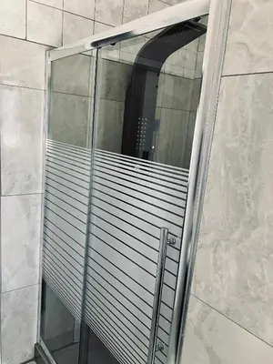 a glass shower door with a window in a bathroom at Willow Cottage in Evander