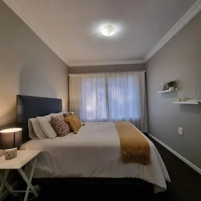 a bedroom with a large bed with a window at Kruin suite in Pretoria
