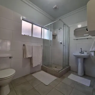 a bathroom with a shower and a toilet and a sink at Kruin suite in Pretoria