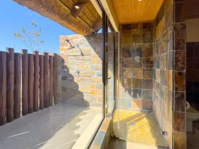 a room with a stone wall and a window at Buffalo Game Lodge in Warmbaths
