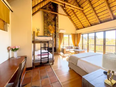 a bedroom with a bed and a desk in a room at Buffalo Game Lodge in Warmbaths
