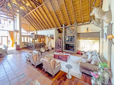 a large living room with couches and a fireplace at Buffalo Game Lodge in Warmbaths