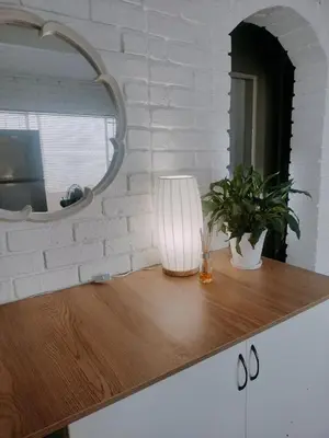 a table with a lamp and a mirror on it at Stay at Percy2 in Nelspruit