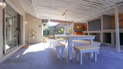 a patio with a table and benches on a house at Stay at Percy2 in Nelspruit