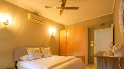 a bedroom with a bed and a ceiling fan at Stay at Percy2 in Nelspruit
