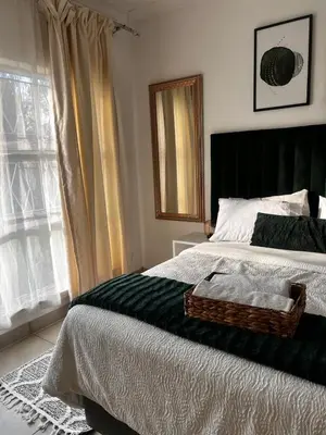 a bedroom with a bed with a tray on it at Pebetzel Luxury Home XX2 in Kempton Park