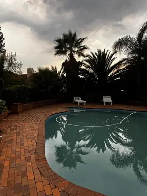 a reflection of a palm tree in a swimming pool at Pebetzel Luxury Home XX2 in Kempton Park