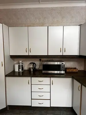 a kitchen with white cabinets and a microwave at Pebetzel Luxury Home XX2 in Kempton Park