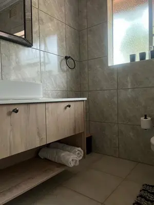 a bathroom with a sink and a mirror at Pebetzel Luxury Home XX2 in Kempton Park