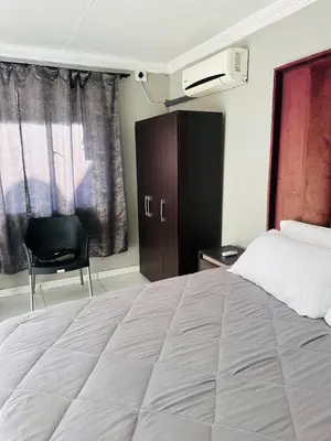 a bedroom with a large bed and a chair at Rose's Lodge