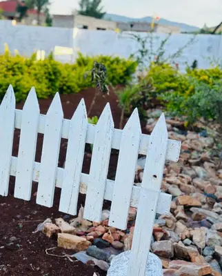 a white picket fence in a garden at Rose's Lodge
