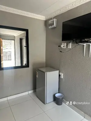 a small refrigerator in a room with a window at Rose's Lodge