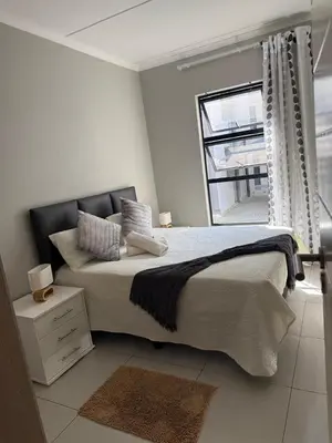 a bedroom with a large bed and a window at 1 bedroom cozy flat in Midrand