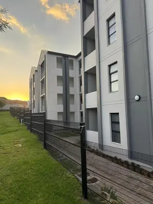 a white building with a fence in front of it at 1 bedroom cozy flat in Midrand