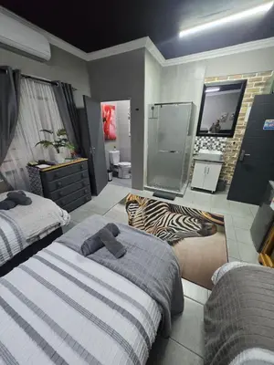 a bedroom with two beds and a zebra rug at Calabash Executive Stay in Benoni