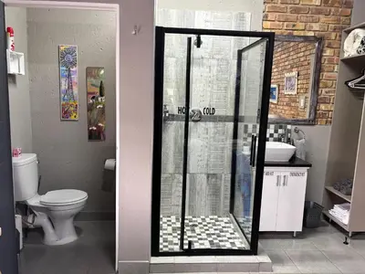 a bathroom with a glass shower with a toilet at Calabash Executive Stay in Benoni