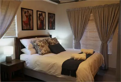 a bedroom with a bed with pillows on it at Casa Beato in Pretoria