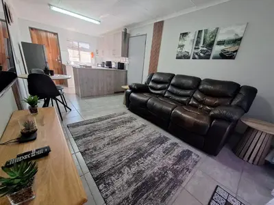 a living room with a leather couch and a table at Casa Beato in Pretoria