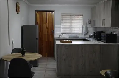 a kitchen with a table and a refrigerator at Casa Beato in Pretoria