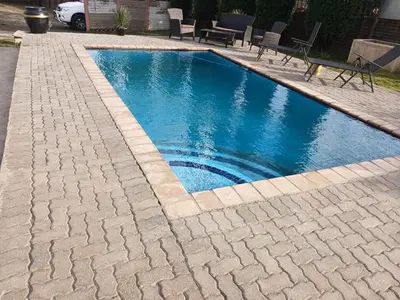 a swimming pool with blue water in a driveway at Tushiya in Witbank