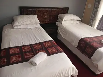 two beds sitting next to each other in a room at Tushiya in Witbank