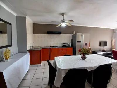 a kitchen with a dining room table with a ceiling fan at Tushiya in Witbank